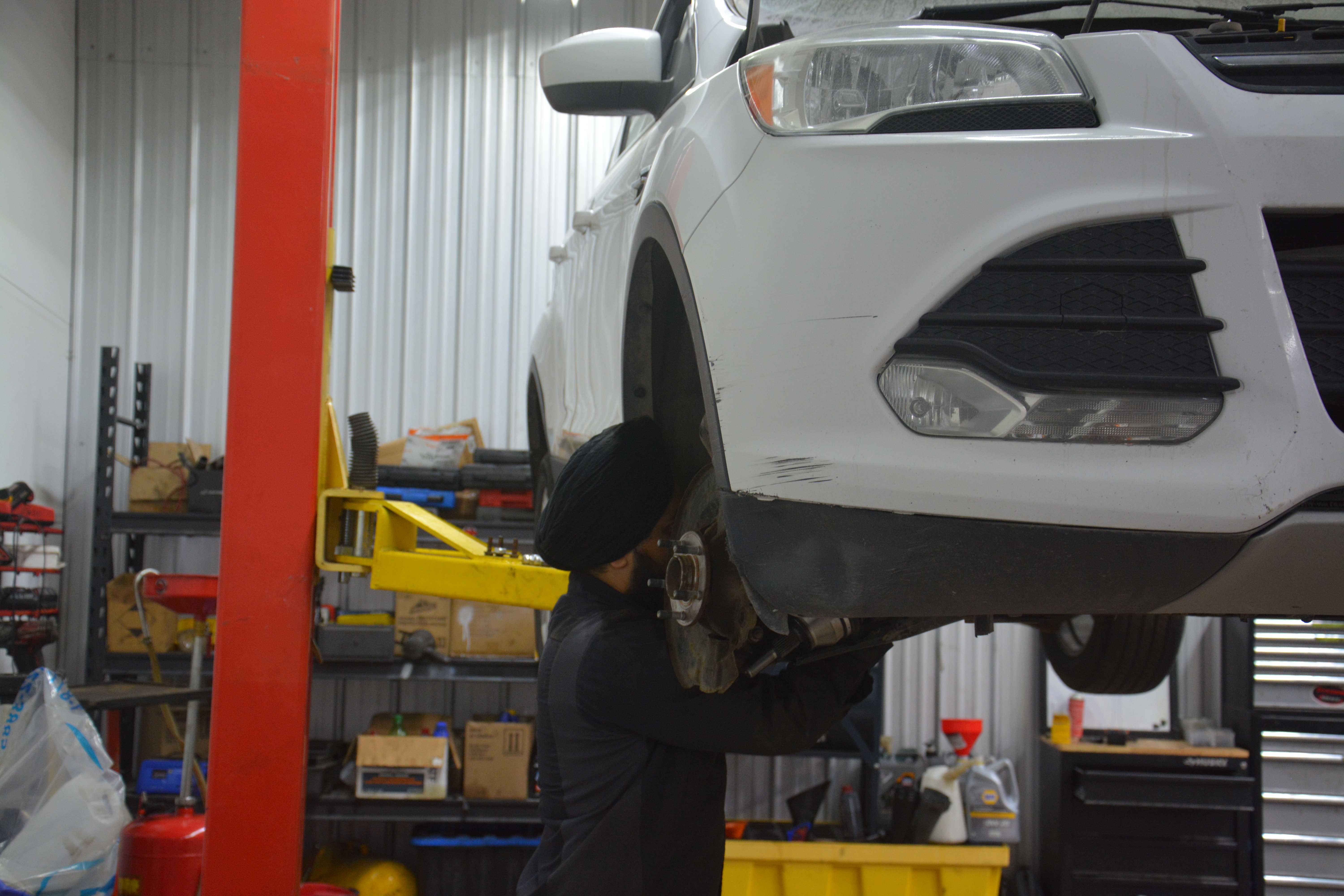 Professional mechanic working on vehicle at Headon Tires workshop